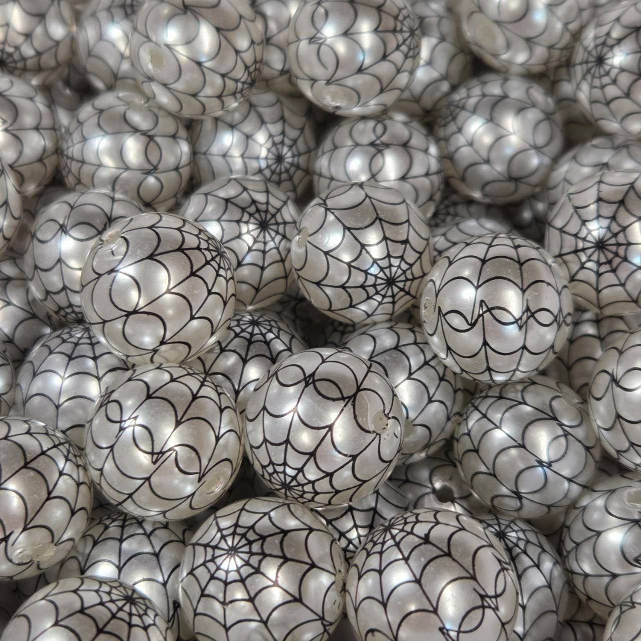 Pearlescent white 20mm printed acrylic bead featuring a black spiderweb design for Halloween and gothic craft projects.