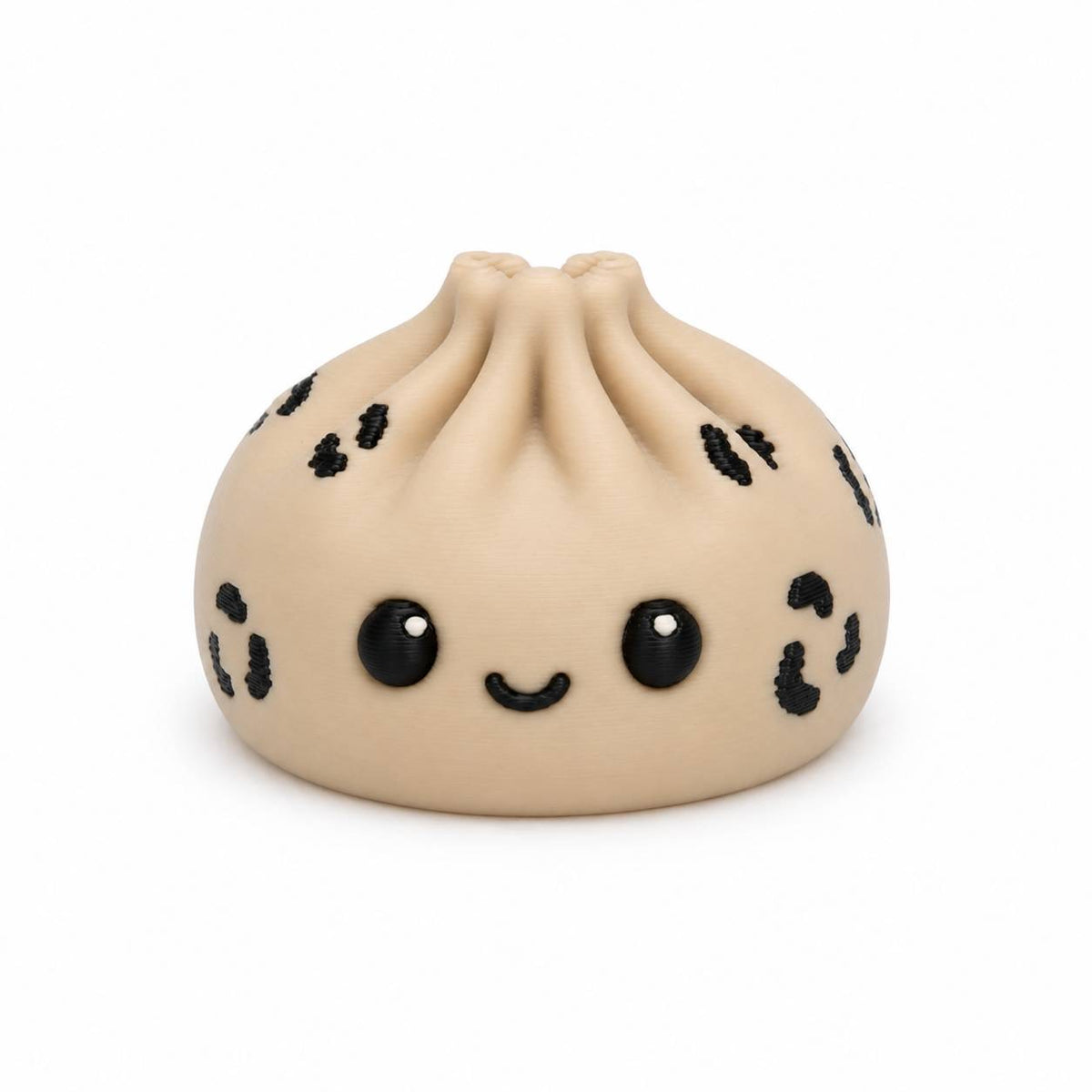 A cute, kawaii-style silicone squishy toy shaped like a steamed bun (baozi dumpling) in beige with black spots and a smiling face, shown on a plain white background.