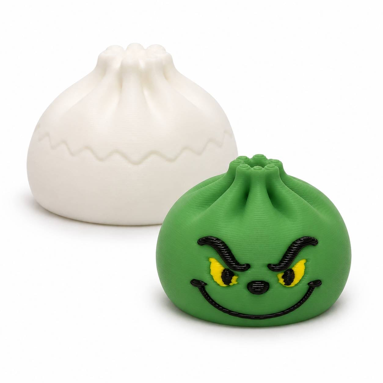 Green Mischief Mini Dumpling 22mm 3D printed bead with yellow eyes and mischievous face shown with Original Dumpling for size comparison