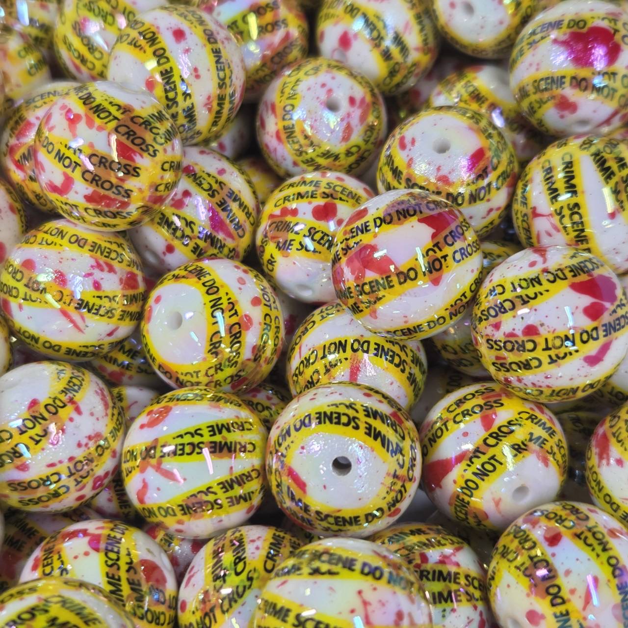 White 20mm printed acrylic bead featuring yellow crime scene tape and red splatter details for Halloween and mystery-themed craft projects.