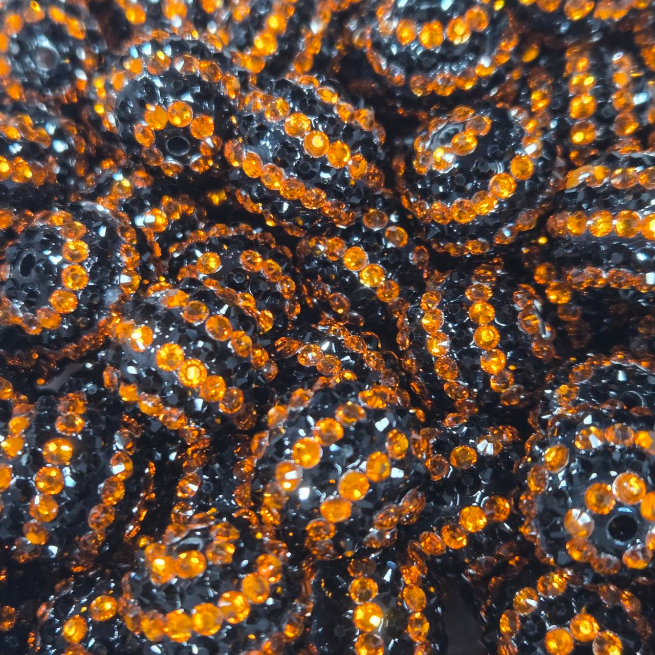 Black 20mm acrylic bead with black rhinestones and bright orange rhinestone stripes for Halloween crafts.