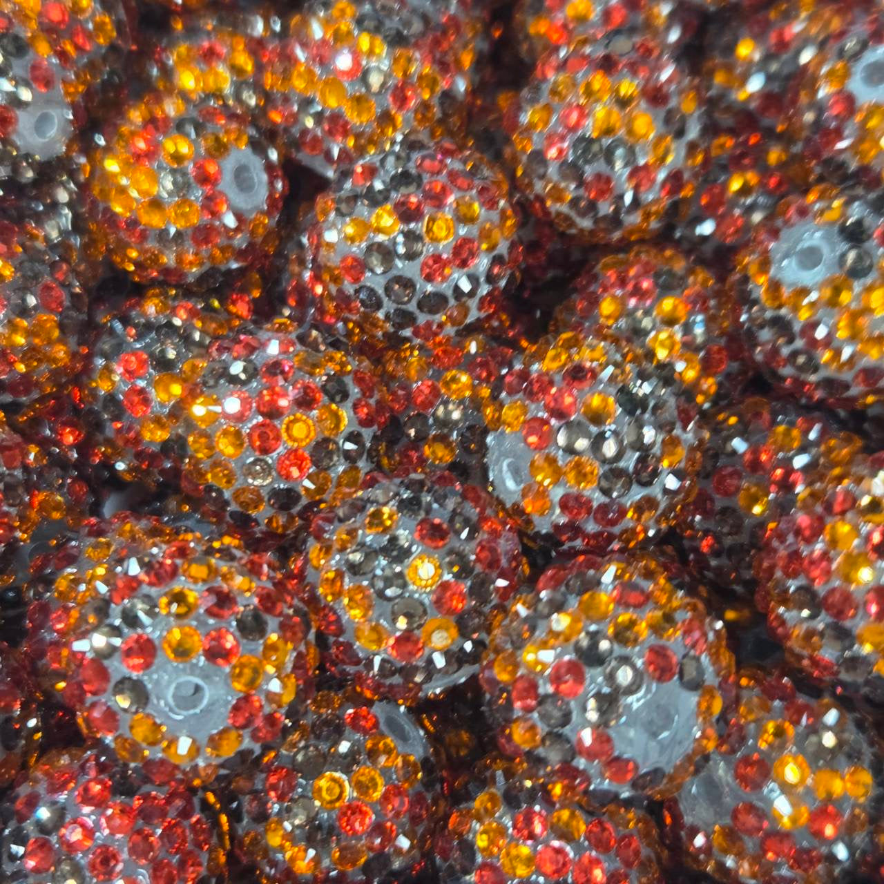 White 20mm acrylic bead with red, orange, and black rhinestones for Halloween and fall-themed craft projects.